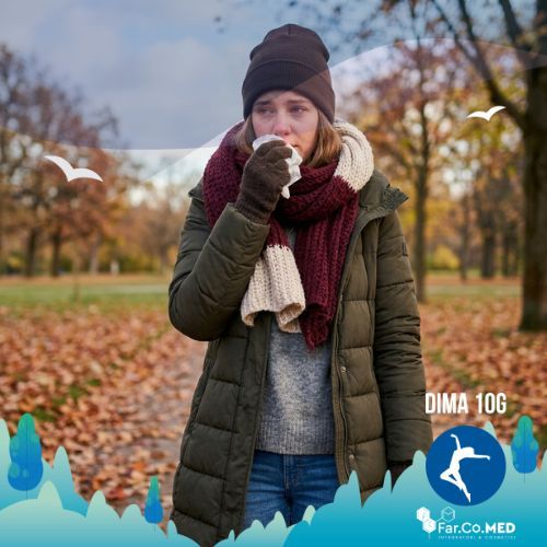 Una donna in un parco autunnale soffre di congestione nasale e rinite allergica alimenti da evitare. La ragazza indossa abiti pesanti, ha il naso arrossato e utilizza un fazzoletto, rappresentando i tipici sintomi della rinite che possono essere mitigati attraverso una dieta specifica.