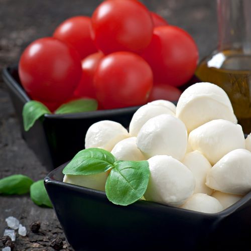 Bocconcini di mozzarella fresca con pomodorini e basilico, un piatto ideale per la mozzarella e dieta chetogenica.