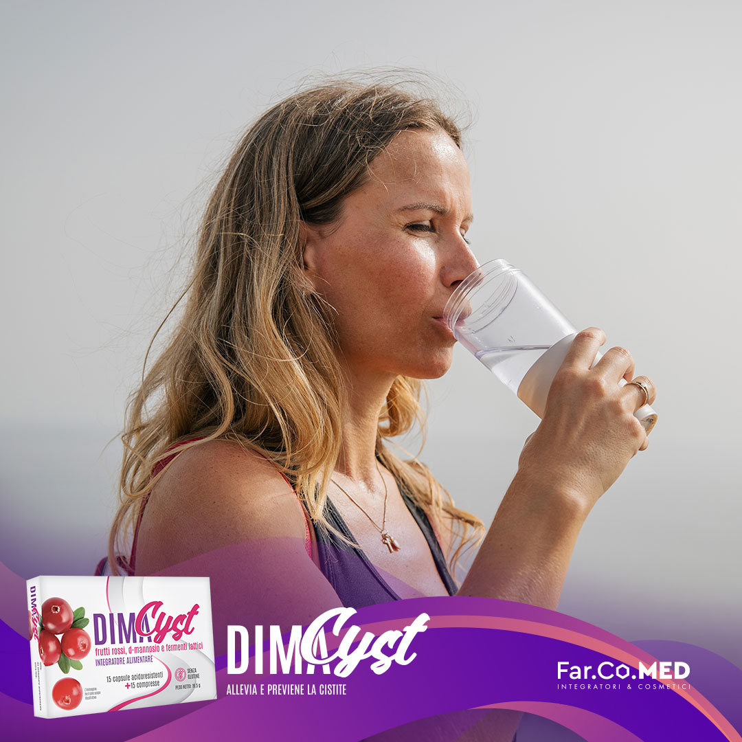 Una donna beve un bicchiere d'acqua all'aperto, sottolineando l'importanza dell'idratazione per la salute urinaria insieme all'integratore DimaCyst di Farcomed, formulato con d-mannosio e frutti rossi per alleviare e prevenire la cistite.