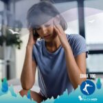 Donna seduta sul letto con le mani alle tempie, espressione sofferente e affaticata che rappresenta i sintomi tipici del brain fog.